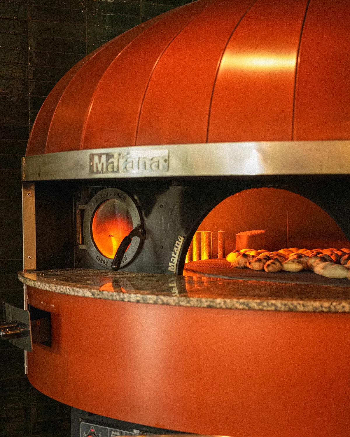Le four à pizza Marana rouge de la trattoria, pâtons en cuisson