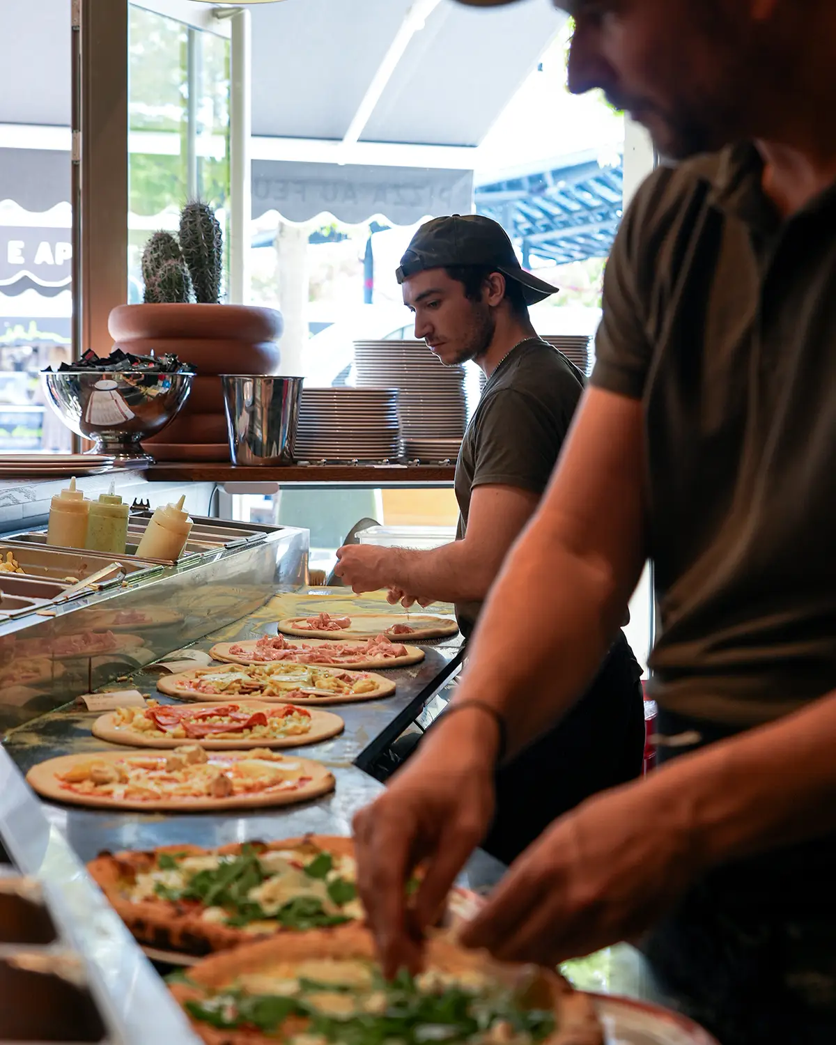 L'équipe prépare les pizzas au comptoir